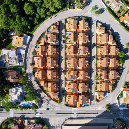 Drone point of view, aerial shot of spanish town of Dehesa de Campoamor during sunny day with high-rise residential buildings, view from above. Spain